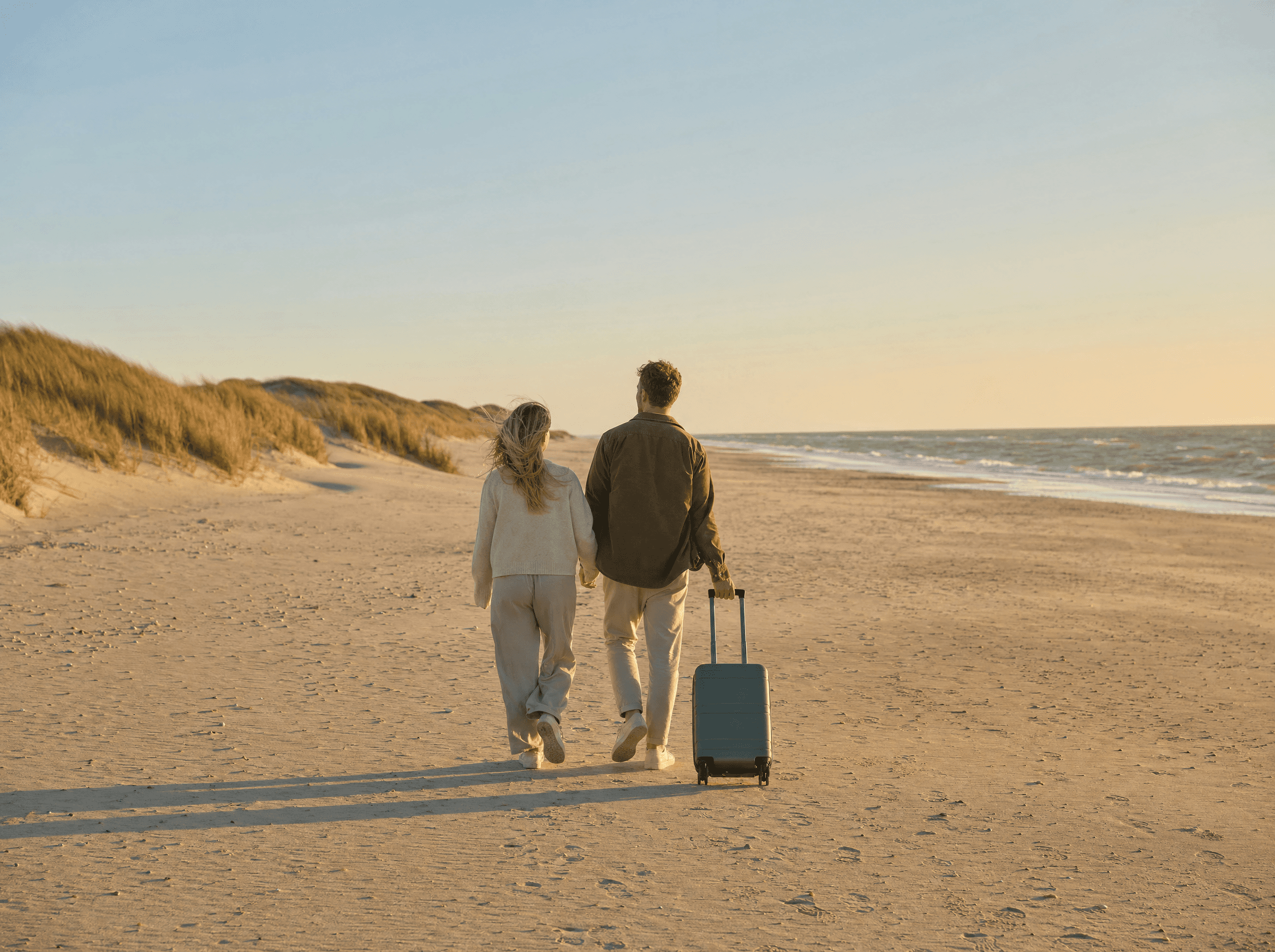 Paar spaziert bei Sonnenuntergang am Nordseestrand